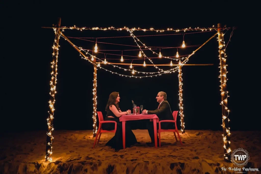 Indian couple at a candlelit engagement dinner set-up under fairy lights, engagement photography in Indore