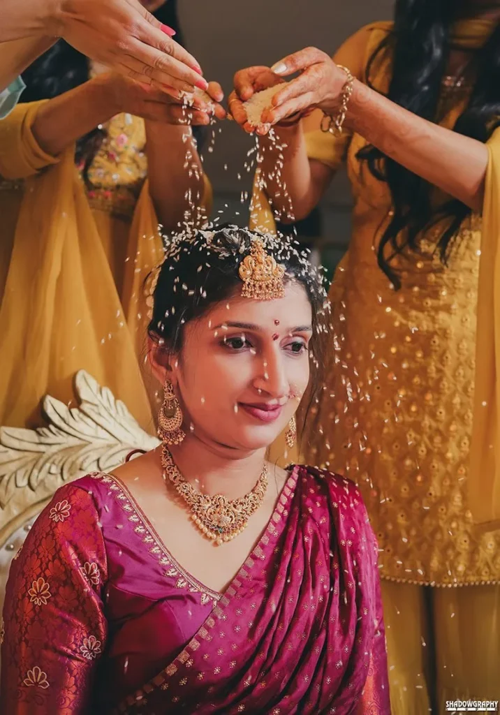 Bride during a haldi ceremony with family applying turmeric, wedding in Indore by The Wedding Panchnama