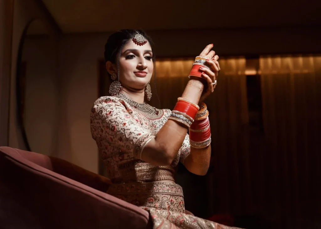 Bride in traditional outfit with chooda bangles and mehendi, wedding in Indore by The Wedding Panchnama