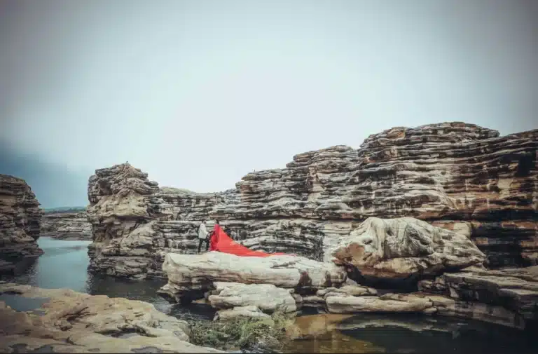 Couple in a red gown among rock formations at Chidiya Bhadak, Khandwa Road