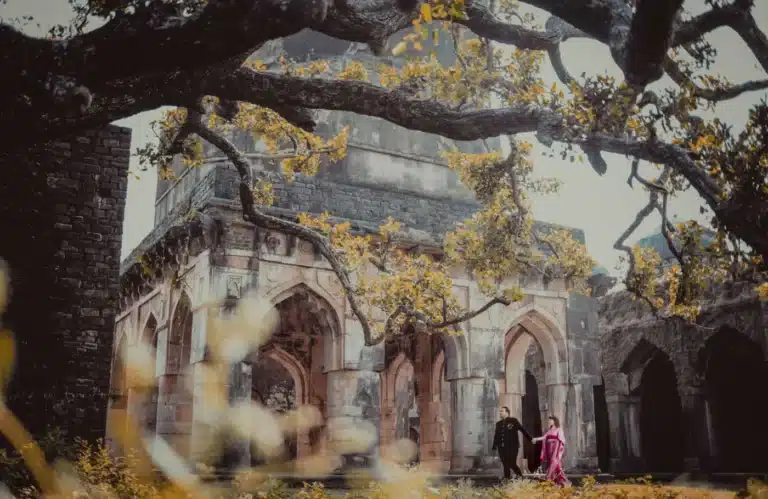 Couple walking through heritage arches at Mandu