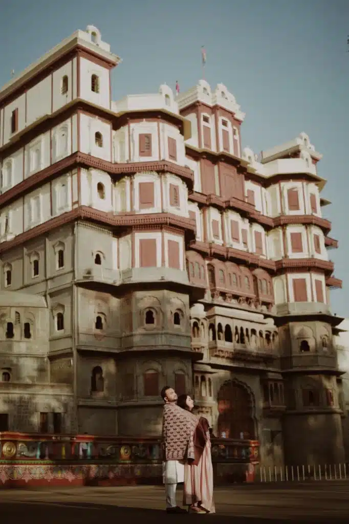 Couple standing in front of the palace facade at Rajwada, Indore